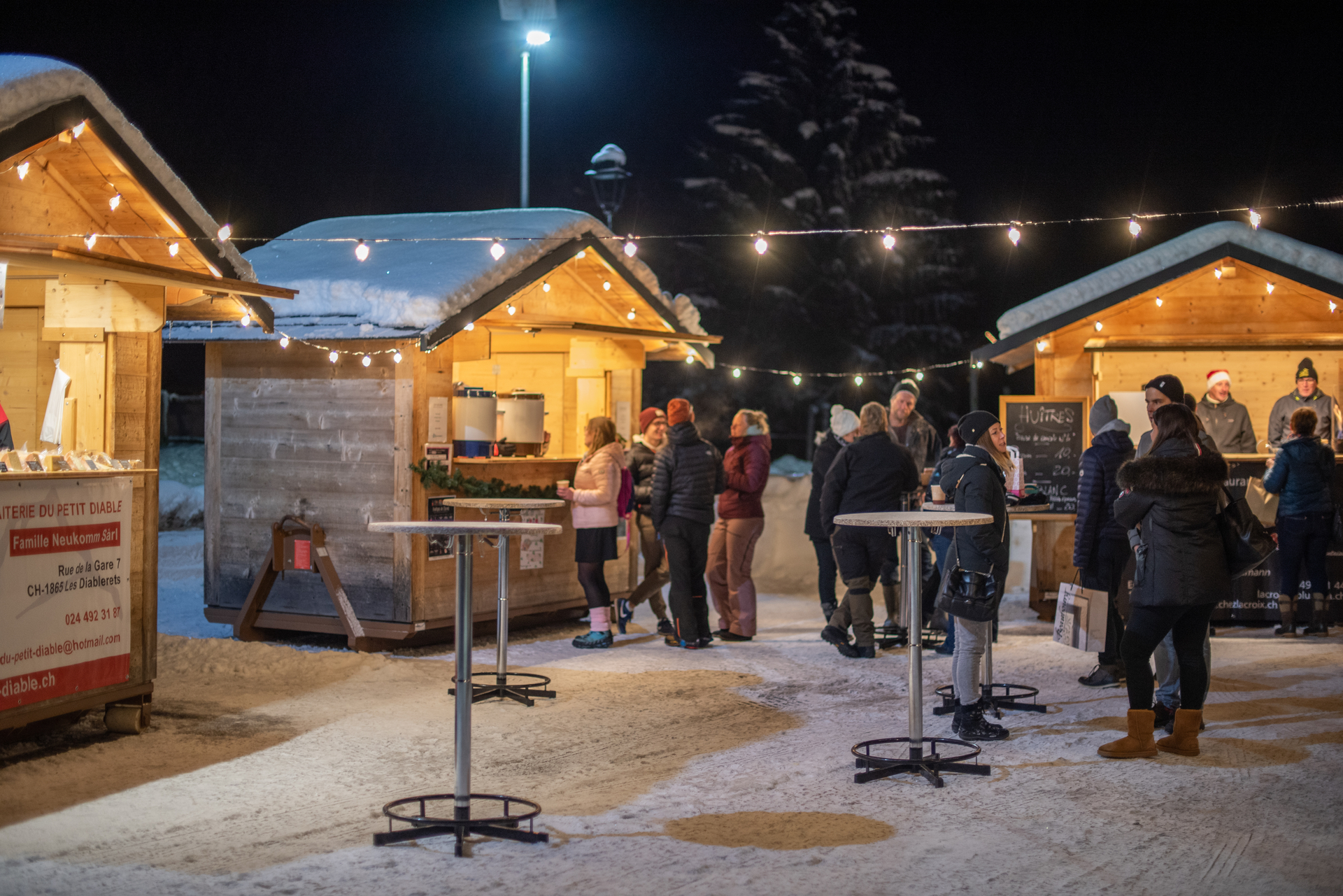 Zusätzlich zu den Handwerksständen im Inneren tauchen die im Freien aufgestellten Chalets in die winterliche Kulisse des Tals ein