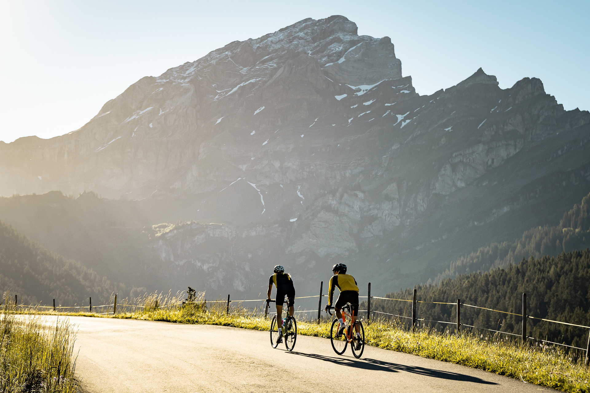 Cycliste au coucher du soleil sur la route du col de la Croix, le massif des Diablerets en toile de fond