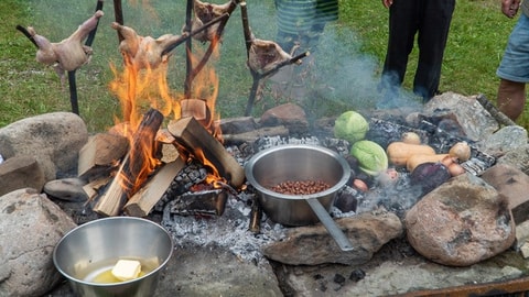 Cours de cuisine archaïque sur le feu en forêt
