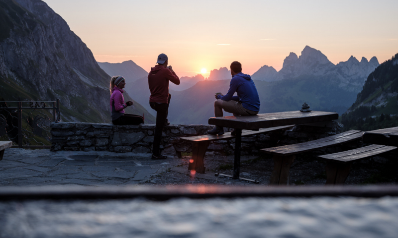 Personen auf Terrasse Cabane des Marindes mit Sonne und Bergen - Sommer - Pays-d'Enhaut - Pascal Gertschen