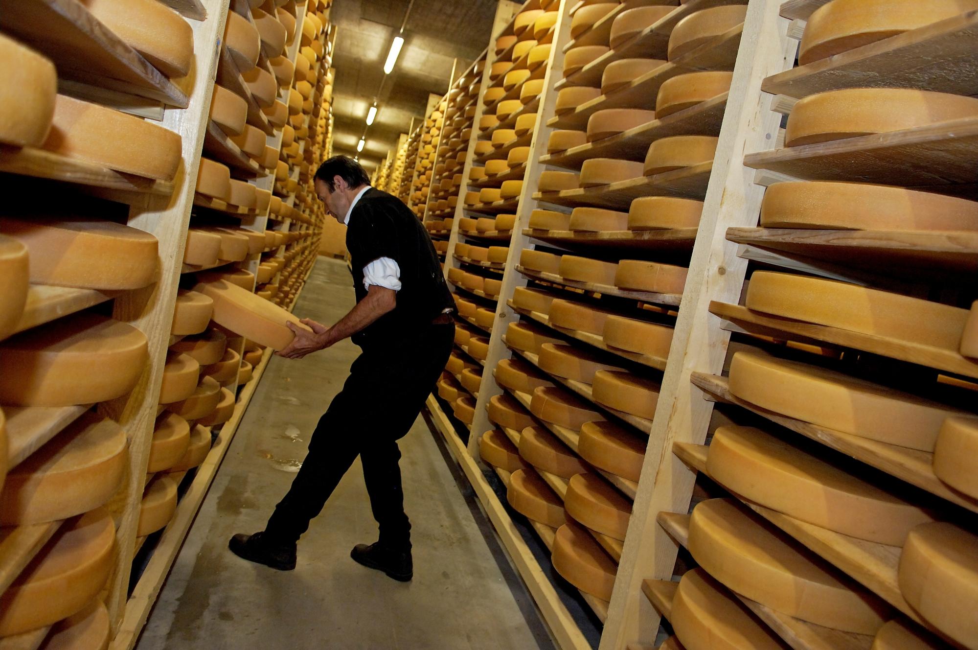 Caves à fromage etivaz avec homme qui porte une meule - pas de saison - Etivaz - Atelier Mamco