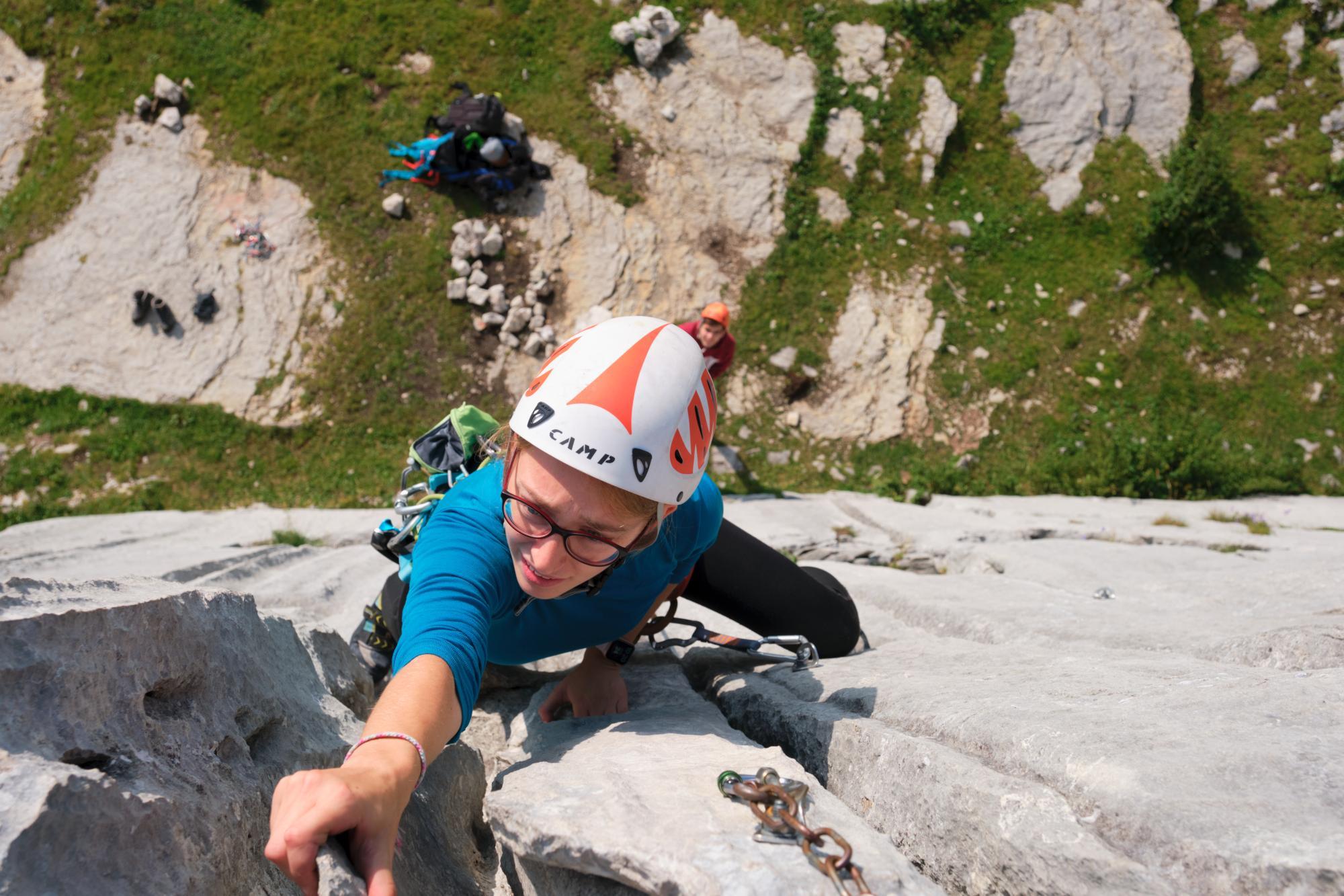 Fille qui grimpe à "Wall Street" à Leysin, vue depuis l'arrivée de la voie d'escalade.