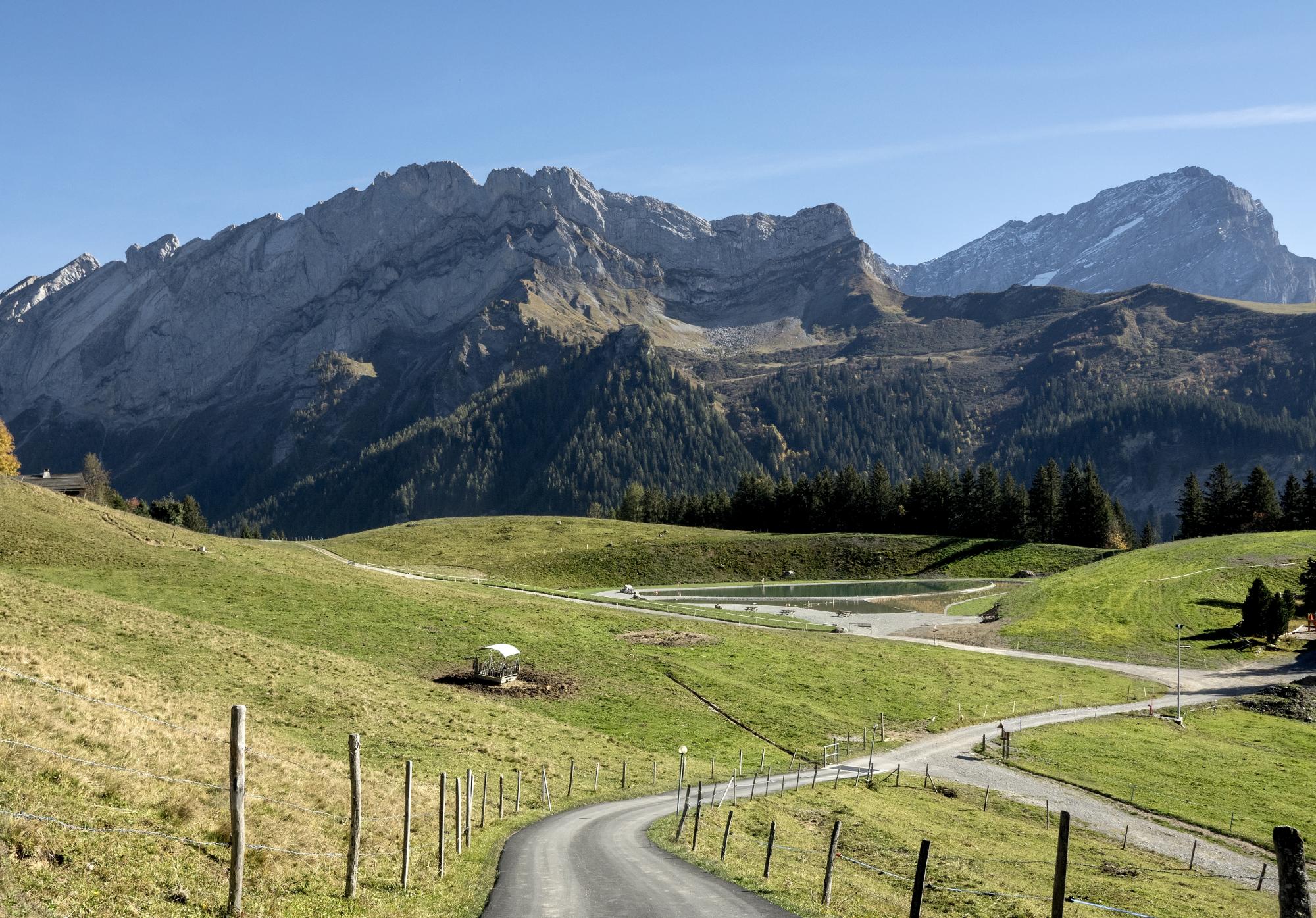 A swimming lake nestled in alpine pastures